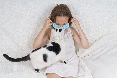 戴着防护面具的生病少女，旁边是一只猫。