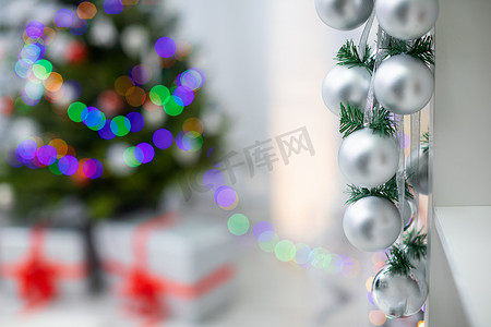 与银色丝带的中看不中用的物品在源分支和背景中的圣诞树上。