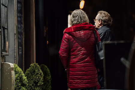 照片上是两人退休男女在晚饭后在街灯会外见面聊天。