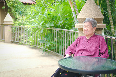 亚洲老年妇女在阳台露台上休息放松。