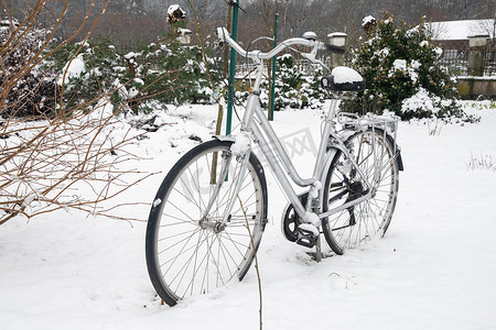 自行车被遗忘在覆盖着白色新雪的院子里，冬天的场景