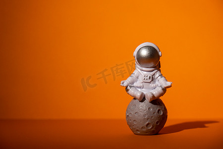 五颜六色的橙色背景的塑料玩具宇航员复制空间。