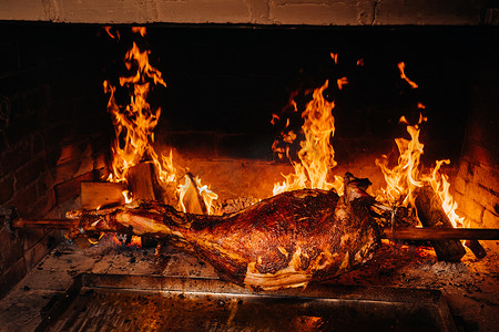 吐口水卡通摄影照片_羊肉完全在火上烤熟。
