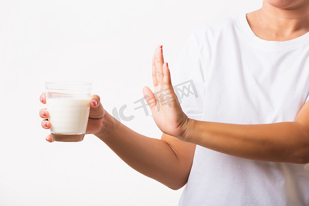 女人举起手来停止标志，用手拿着玻璃牛奶她