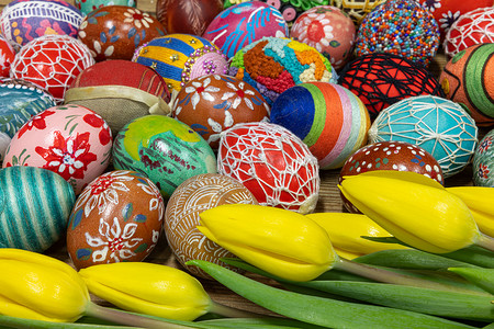 五颜六色的复活节彩蛋和黄色的郁金香花充满了整个画面。