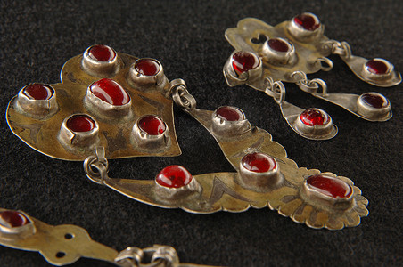 珠宝设计中摄影照片_中亚黑色背景中镶嵌着珍贵红宝石的古董胸针