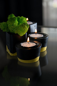 台中摄影照片_黑色和黄色混凝土烛台中的蜡烛和苔藓