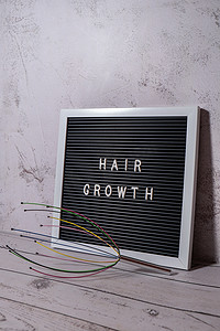 家用头皮按摩器，带有字母板 HAIR GROWTH 文本。