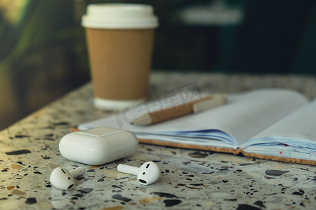 样机纸质摄影照片_用带无线耳机的纸质笔记本带走工艺回收纸杯中的咖啡。