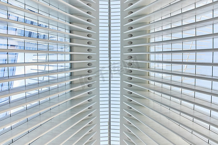 对称建筑摄影照片_直视干净的现代白色建筑天花板，与玻璃对称，向外