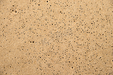 洞阳光摄影照片_有雨洞的海滩沙子