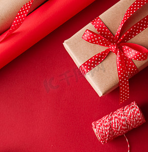 圣诞节准备、节礼日和节假日送礼、圣诞牛皮纸和红色背景礼盒丝带作为包装工具和装饰品、DIY 礼物作为节日平铺