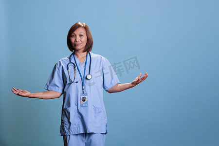 亚洲老年护士在蓝色背景的工作室里做我不知道的手势