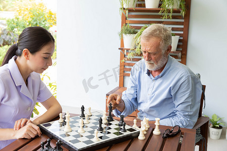 退休老人在家和护士下棋