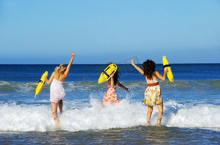 夏日玩乐摄影照片_三名年轻女子在夏日的沙滩上玩乐