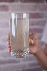 化学垃圾摄影照片_拿着一杯脏水的男人