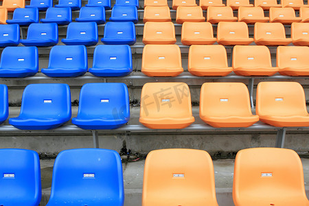 塑料，黄色和蓝色，体育场内的新椅子。