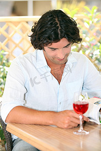 男人在阳光下拿着一杯玫瑰阅读
