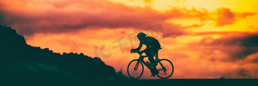公路自行车铁人三项赛骑自行车者在日落背景天空横幅全景中参加赛车自行车比赛