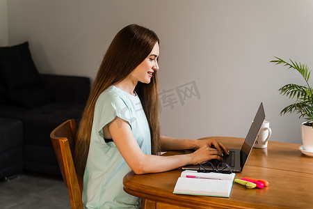 性格开朗的女孩，在家里用笔记本电脑打字，与朋友和家人聊天。