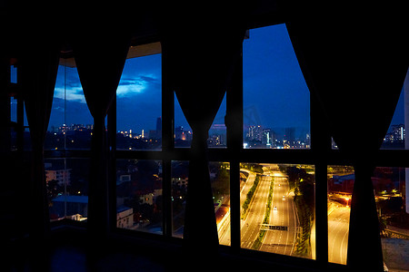 从公寓窗户向大都市方向的多车道高速公路上的夜景。