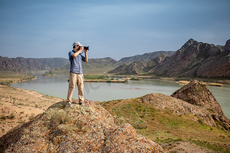 摄影师在哈萨克斯坦阿拉木图地区伊犁河畔的山顶拍摄风景