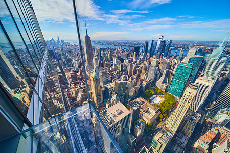 河夕阳摄影照片_纽约市的玻璃地板高高耸立，俯瞰城市