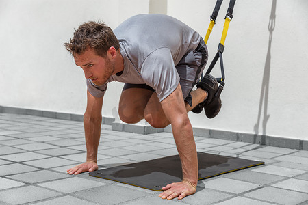 男子在健身房用悬挂健身带训练 abs 核心身体肌肉。
