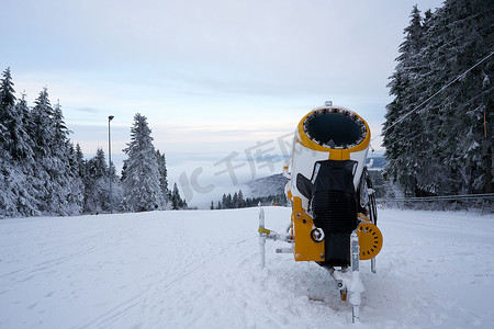雪扇摄影照片_德国罗恩黑森州 Wasserkuppe 滑雪胜地的黄色人造雪炮，2022 年 12 月新降雪后的雪山上