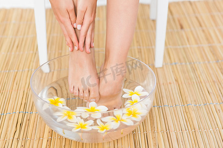女人在一碗花中洗脚