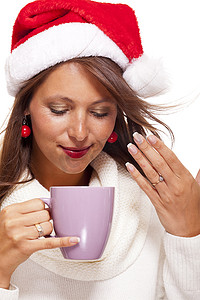 咖啡茶摄影照片_戴着圣诞帽喝着咖啡茶的冷漠年轻女人