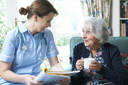 护士记录摄影照片_护士在家与老年妇女讨论医疗记录
