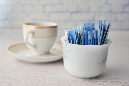 糖替代甜味剂放在一包茶里，桌上放着一杯茶