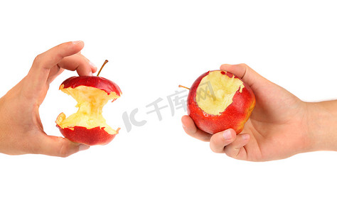 手拿着核心和轻咬的苹果。