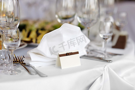 餐饮卡片摄影照片_将卡片放在白色的节日餐桌上