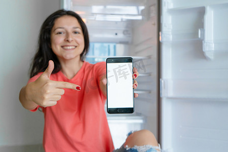 智能冰箱摄影照片_一个女孩用智能手机点餐。