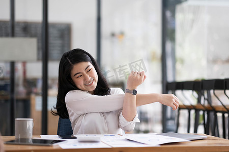 商务女性在家工作并伸展身体，因为在平板电脑上工作后感到疲倦，生活方式女性在家工作后放松概念。