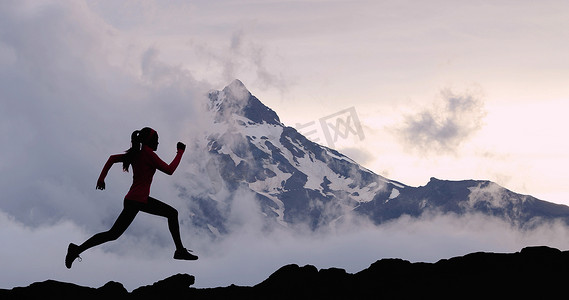 在山峰背景下跑步的女运动员足迹。