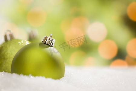 抽象背景下雪地上的绿色圣诞饰品