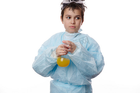 穿着实验室外套的聪明少年拿着一个装有黄色化学液体的玻璃瓶，在白色背景下做实验