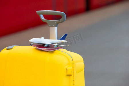 火车站黄色行李上的红色护照和飞机小模型