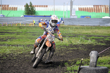 骑摩托车赛车摄影照片_骑摩托车的摩托车手参加越野比赛。
