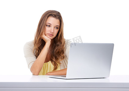 zzz摄影照片_我想我已经看到了一切......一个迷人的年轻女人在她的笔记本电脑上工作时看起来很无聊。