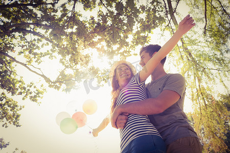 可爱的情侣在公园里拥抱和拿着气球