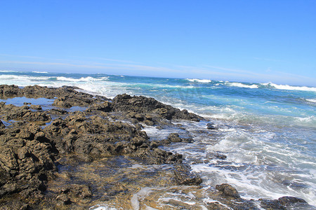 带有白色泡沫的汹涌海浪拍打着沿海的石头，富尔特