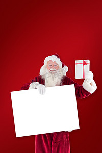 举着牌子的人摄影照片_圣诞老人的合成图像在举着牌子的同时展示礼物