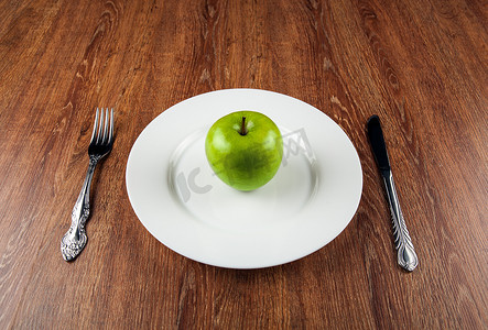 餐桌约会和白盘子上的新鲜青苹果