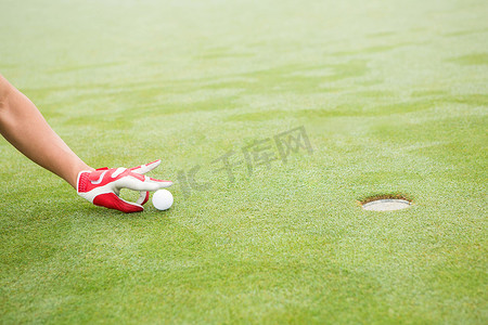 高尔夫球手试图将球弹入洞中