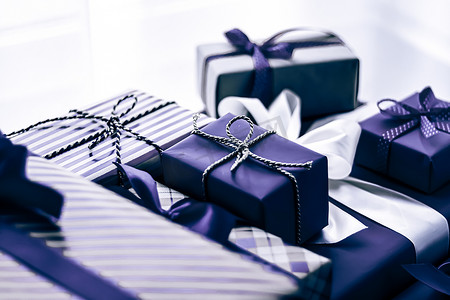 节日礼物和包装好的豪华礼物、紫色礼盒作为生日、圣诞节、新年、情人节、节礼日、婚礼和假日购物或美容盒交付的惊喜礼物
