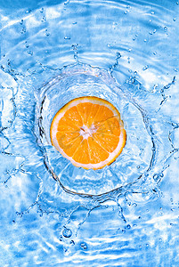 水里气泡摄影照片_新鲜的橙子掉进水里，气泡被白色隔开